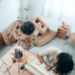 Canva - Faceless black kids drawing and playing on carpet at home